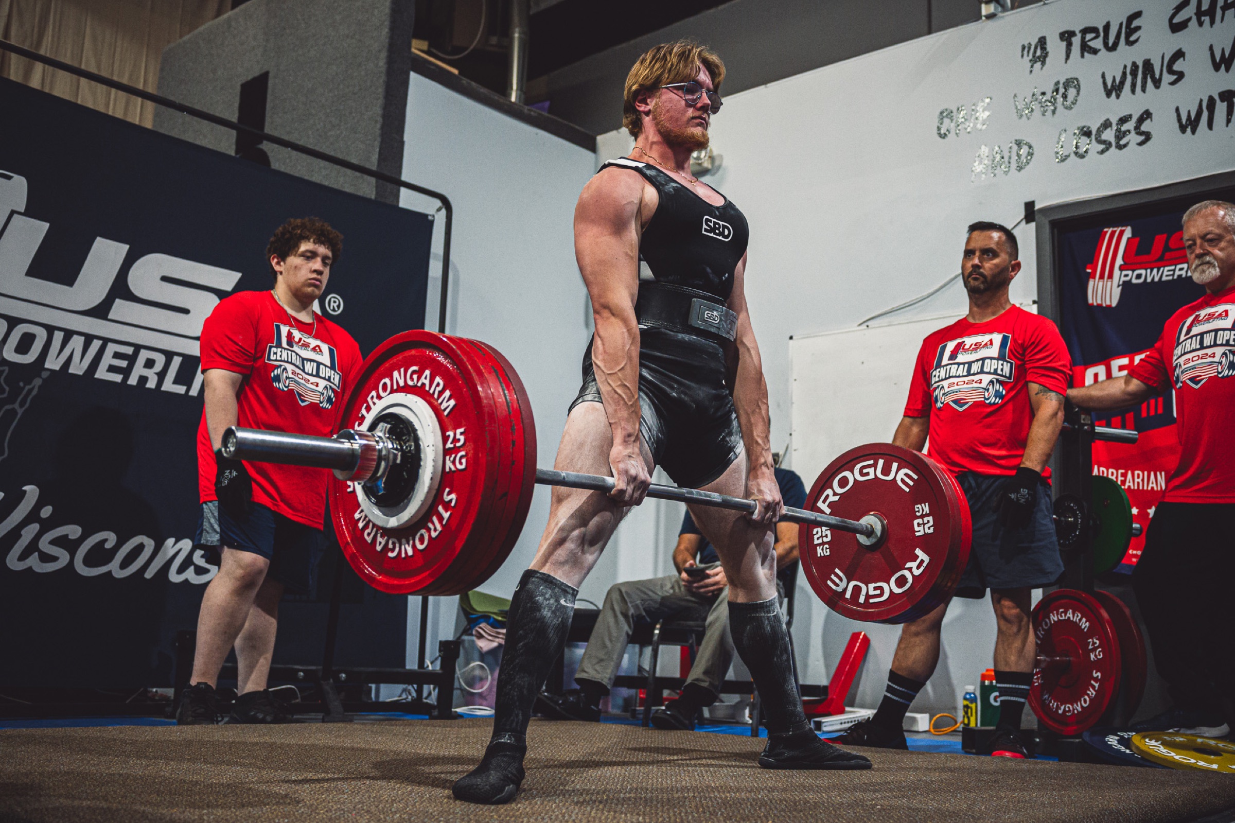 Powerlifter completing a deadlift at a meet